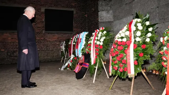 Charles stands back after laying a wreath among others