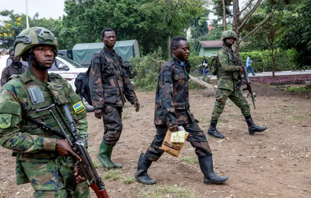 Rwandan soldiers escort members of the Armed Forces of the Democratic Republic of the Congo who surrendered in Goma