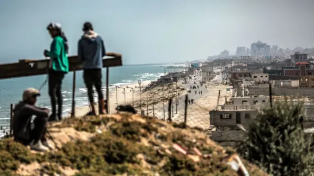 Youths gather atop an elevated area in al-Zahra in the central Gaza Strip