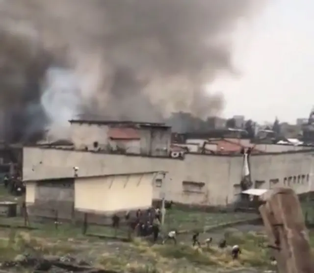 Screengrab from video showing Goma jail and smoke rising in background