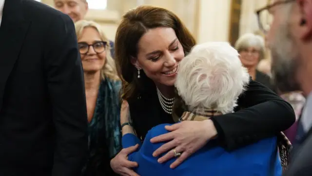 Princess Kate, hugging an elderly woman in a blue coat