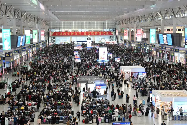 Tourists wait to board a train at Shanghai Hongqiao Railway Station to return home for Chinese Lunar New Year