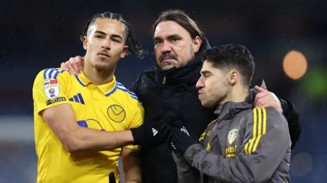 Leeds manager Daniel Farke puts his arms around Mateo Joseph and Manor Salomon at full-time