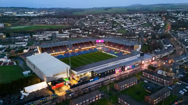 An aerial shot of a floodlit Turf Moor