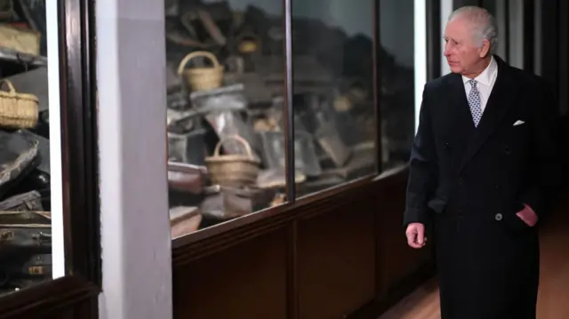 King Charles views the collection of personal items confiscated from victims when they entered Auschwitz-Birkenau