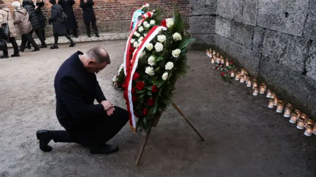 Polish President Andrzej Duda takes a knee in the Auschwitz I former concentration camp site