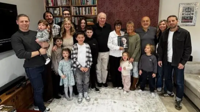 Family photo in home, including parents children and babies