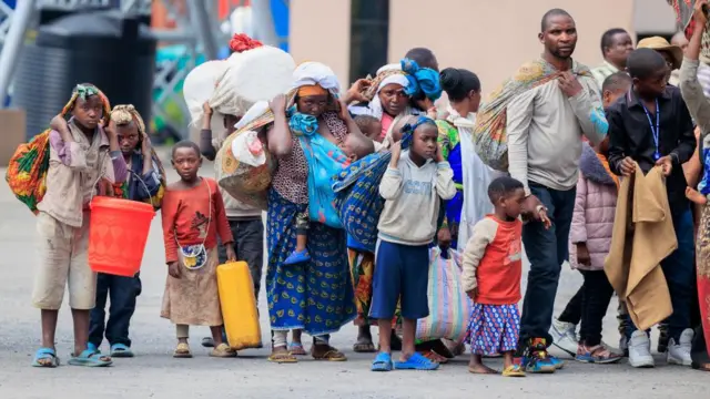 Refugees carry their belongings after crossing the border from Goma in the Democratic Republic of Congo to Gisenyi, Rwanda, 27 January 2025