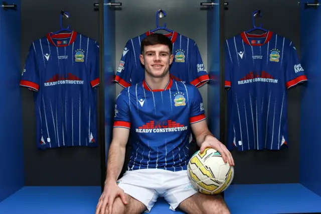 Kieran Offord poses in a Linfield kit