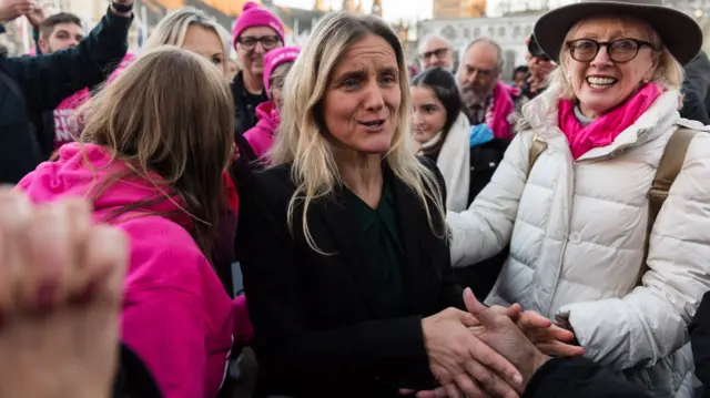 Kim Leadbeater holds the hand of supporters in a crowd