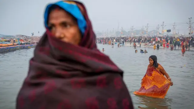 Devotees take a holy dip at Sangam, the confluence of the Ganges, Yamuna and Saraswati river.