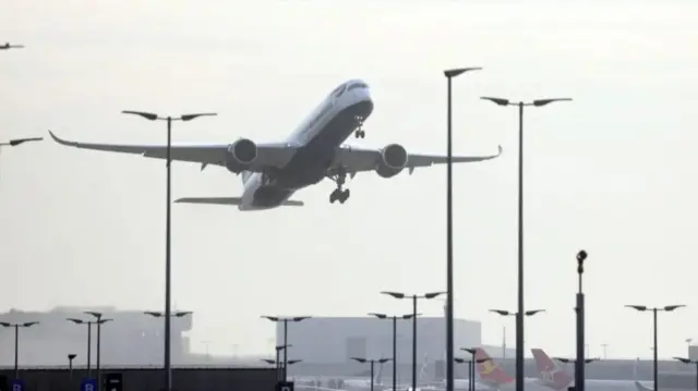 A plane flying up above a runway