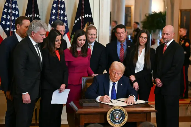 Donald Trump signs Laken Riley Act while surrounded by Republican lawmakers and supporters