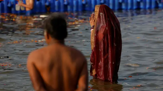 A devotee takes a holy dip at Sangam, the confluence of the Ganges and Yamuna rivers with the mythical, invisible Saraswati river, during the "Maha Kumbh Mela", or the Great Pitcher Festival, in Prayagraj, India, January 28, 2025. REUTERS/Sharafat Ali