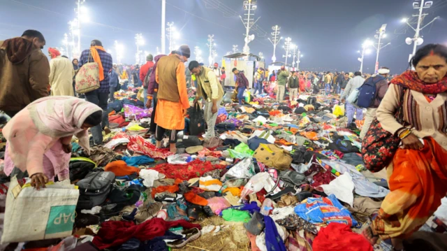 Attendees walk amongst piles of personal belongings after a stampede before the 'Amrit Snan' at the Kumbh Mela