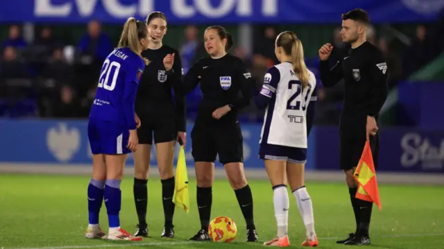 Match Referee Cheryl Foster talks to Megan Finnigan of Everton and Olga Ahtinen of Tottenham Hotspur during the coin toss