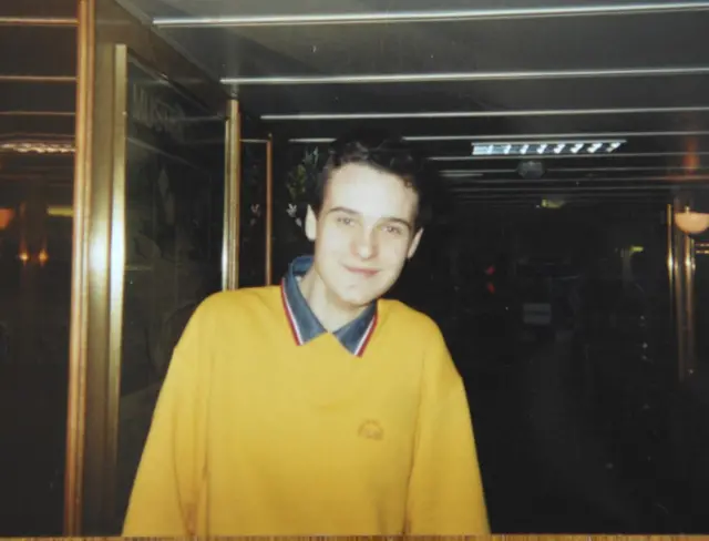 Undated collect of 16-year-old Alan Radford who was killed in the Omagh bombing. he wears a yellow jumper and has short dark hair and smiles at the camera.