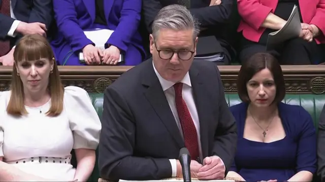 Keir Starmer in a grey suit and red tie in House of Commons