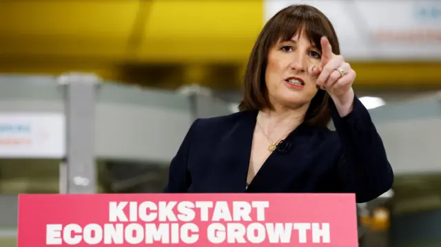 Rachel Reeves stands at podium with the words "kickstart economic growth" on it