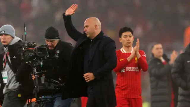 Liverpool manager Arne Slot waves to fans.