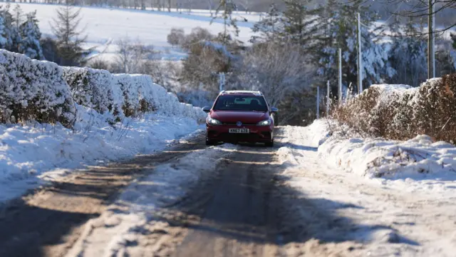 A car drives through snow in Balerno, Edinburgh.