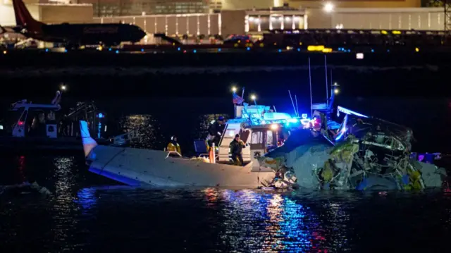 Parts of a plane can be seen in the water of the Potomac river