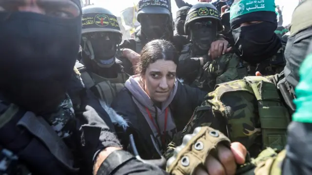 Arbel Yehud walking surrounded by masked men