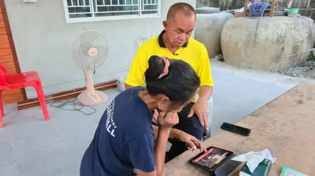 Woman and man watching hostage release news on tablet