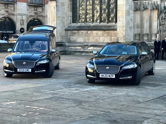 A black jaguar hearse and limousine outside Hull Minster