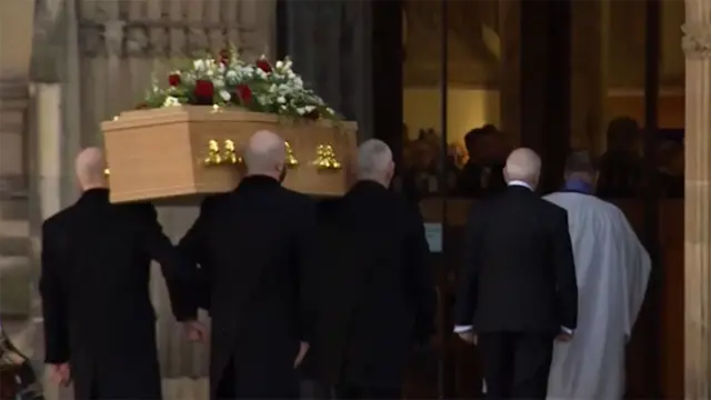 Coffin carried inside