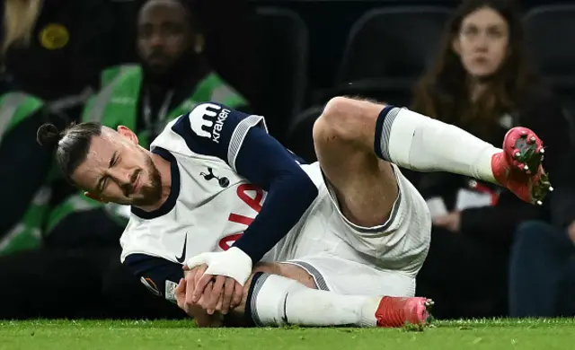 Tottenham Hotspur's Romanian defender #06 Radu Dragusin holds his knee