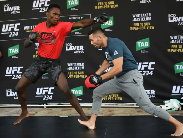 Israel Adesanya throws a punch at his training partner