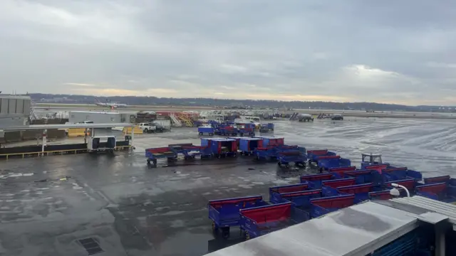 A view of outisde Reagan airport, there are many luggage trolleys visible