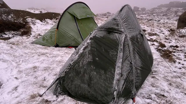 Two tents pitched on snowy ground in the Peak District