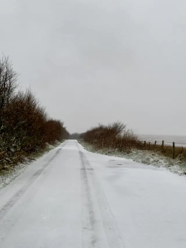 A country path is covered in snow.