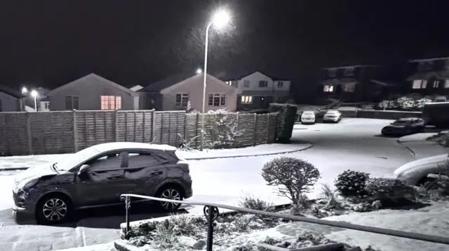 A car on a close covered in snow in Wales