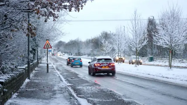 Cars driving on roads covered in snow and ice