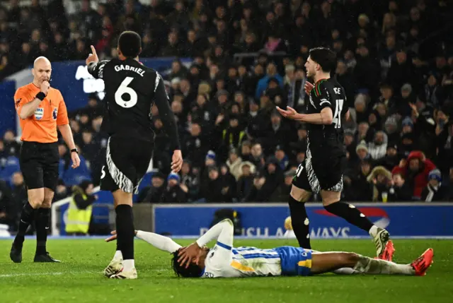 Joao Pedro holds his head after a clash