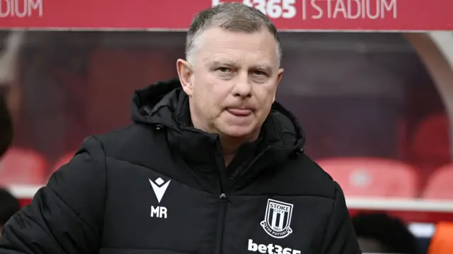 Mark Robins prepares to take his seat in the Stoke dugout