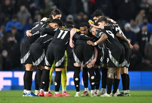 Arsenal players chat in a huddle before the second half begins