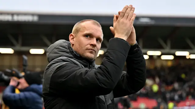 Bristol City head coach Liam Manning claps the home support