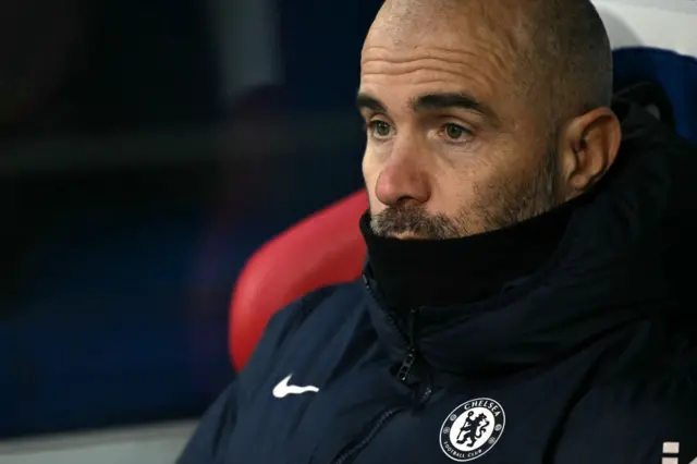 Maresca sits on the bench with his chin in his coat