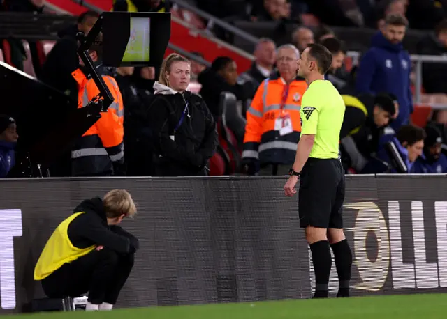 Match referee Stuart Attwell checks the VAR