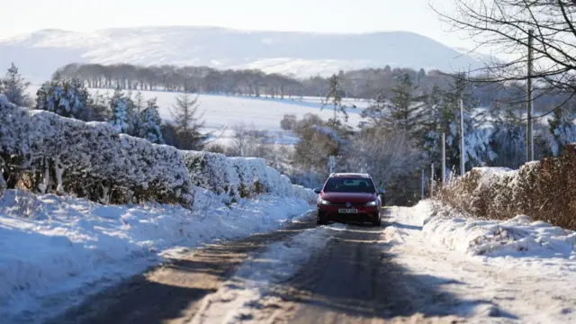 A car drives through snow in Balerno, Edinburgh. The UK Health Security Agency (UKHSA) has issued cold weather health alerts for all of England ahead of a week of low temperatures. Amber alerts have been issued from 12pm on Thursday until January 8, meaning a rise in deaths, particularly among those aged 65 and over or with health conditions, is likely, the UKHSA said. Picture date: Friday January 3, 2025