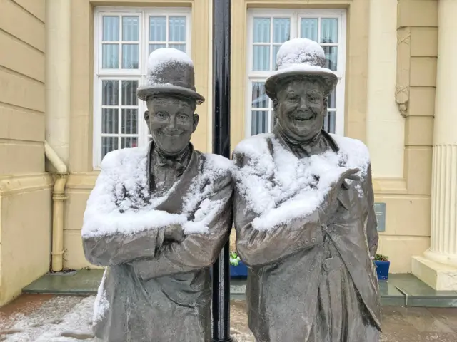 A statue of Laurel and Hardy in Ulverston. The great figures are covered in snow