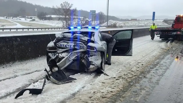 A police car is crumpled on a highway after a crash