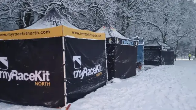 Marquees in a snowy park. The one closest is black and yellow with the myRaceKit logo on.