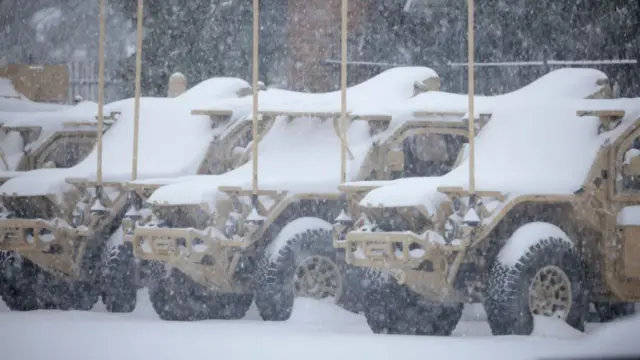 Snow-covered military vehicles parked at the Kentucky Air National Guard base at the airport