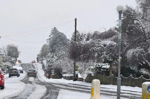 A road and cars covered in nnow