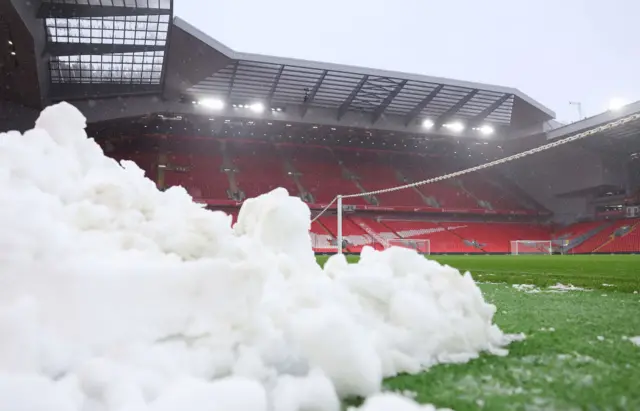 Snow piled high at the side of the pitch